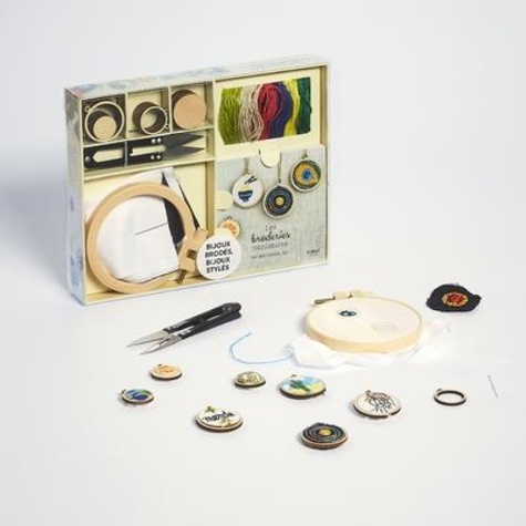 Coffret L'atelier miniature les broderies bijoux. Le livre Les broderies miniatures avec 1 tambour, 10 mini-supports à bijoux, 3 pièces de toile blanche, 2 pièces de toile noire, 1 aiguille, 12 échevettes de fil à broder et 1 paire de ciseaux